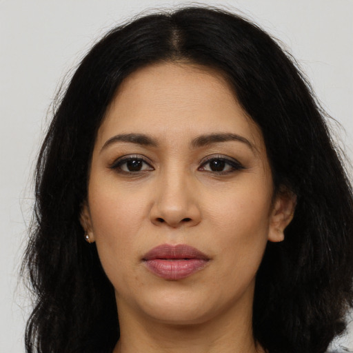 Joyful latino young-adult female with long  brown hair and brown eyes