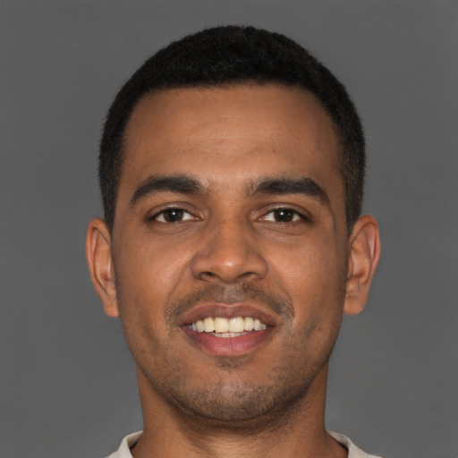 Joyful black young-adult male with short  brown hair and brown eyes