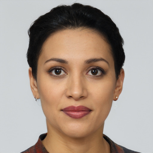 Joyful latino young-adult female with short  black hair and brown eyes
