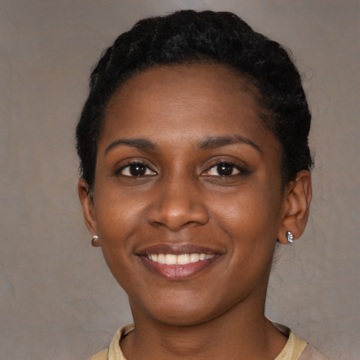 Joyful black young-adult female with short  black hair and brown eyes