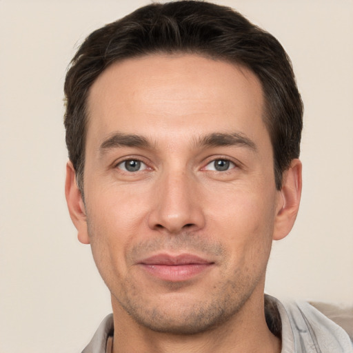 Joyful white young-adult male with short  brown hair and brown eyes