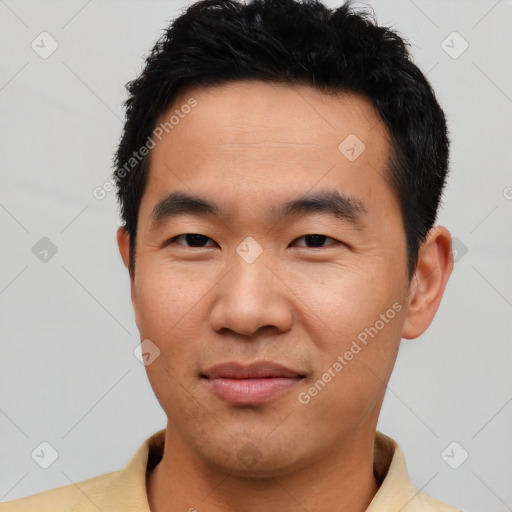 Joyful asian young-adult male with short  black hair and brown eyes