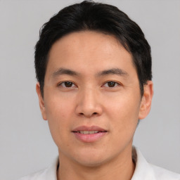 Joyful asian young-adult male with short  black hair and brown eyes