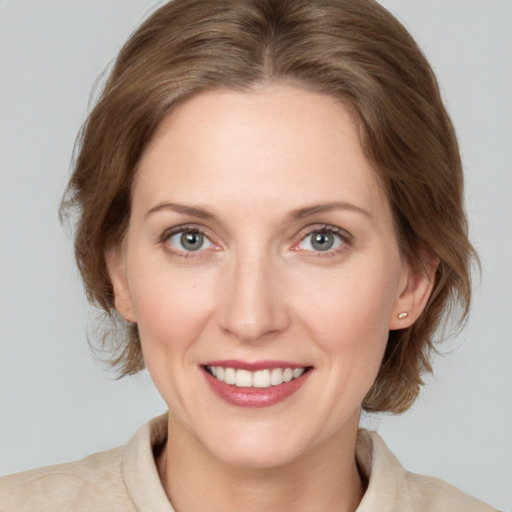 Joyful white young-adult female with medium  brown hair and blue eyes