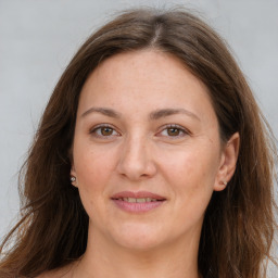 Joyful white adult female with long  brown hair and grey eyes