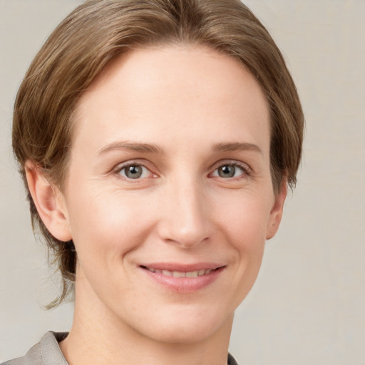 Joyful white young-adult female with medium  brown hair and grey eyes