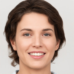 Joyful white young-adult female with medium  brown hair and green eyes