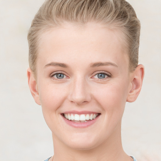 Joyful white young-adult female with short  brown hair and grey eyes