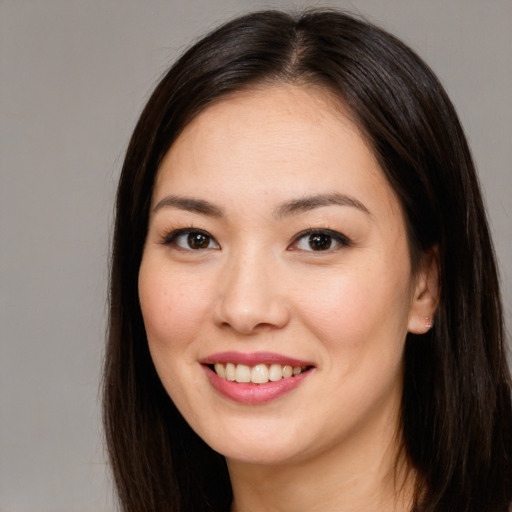 Joyful asian young-adult female with long  brown hair and brown eyes