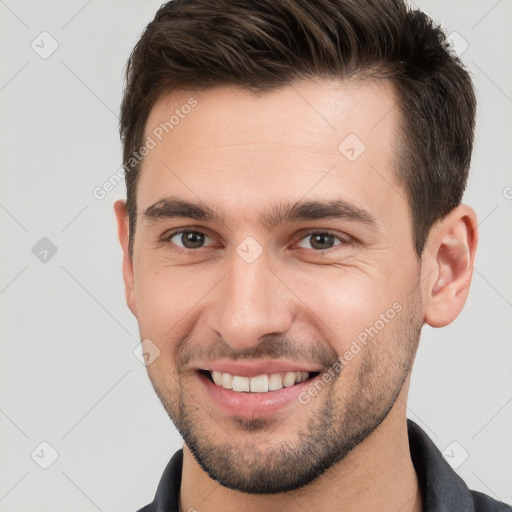 Joyful white young-adult male with short  brown hair and brown eyes