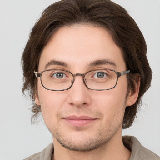 Joyful white young-adult male with short  brown hair and grey eyes