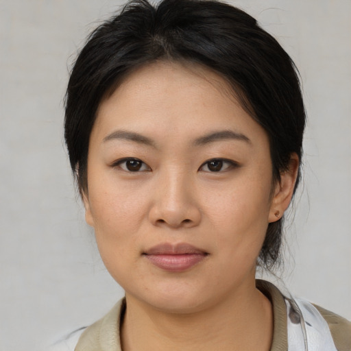 Joyful asian young-adult female with medium  brown hair and brown eyes