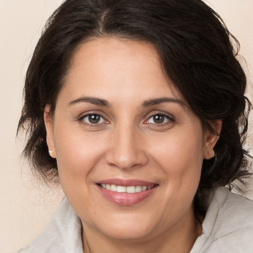 Joyful white adult female with medium  brown hair and brown eyes