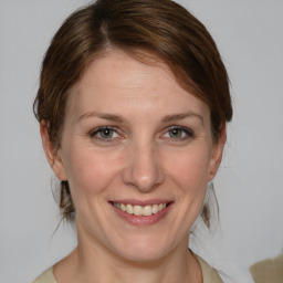 Joyful white adult female with medium  brown hair and blue eyes