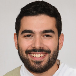 Joyful white young-adult male with short  black hair and brown eyes