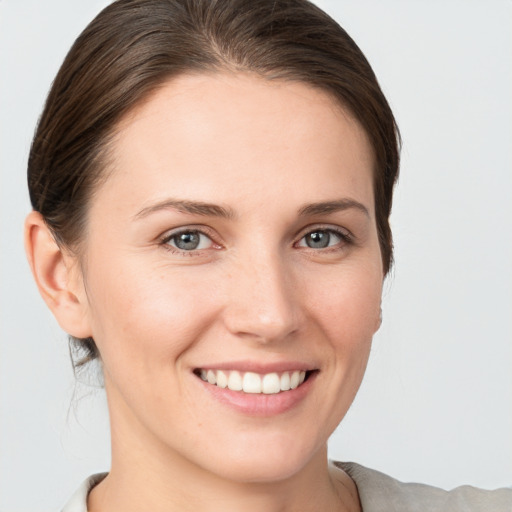 Joyful white young-adult female with medium  brown hair and grey eyes