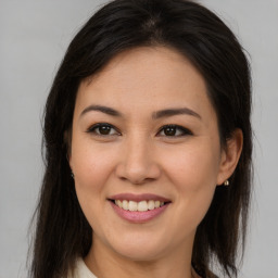 Joyful latino young-adult female with medium  brown hair and brown eyes