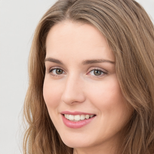 Joyful white young-adult female with long  brown hair and green eyes