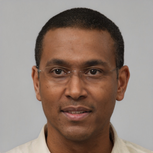 Joyful black adult male with short  black hair and brown eyes