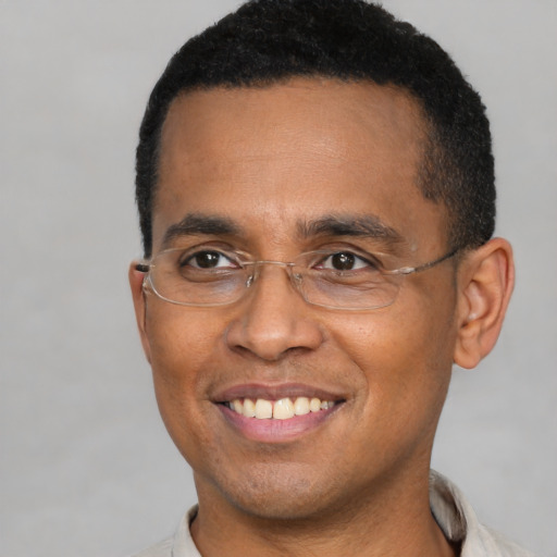 Joyful black adult male with short  brown hair and brown eyes