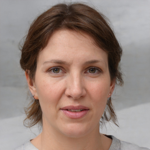 Joyful white adult female with medium  brown hair and grey eyes