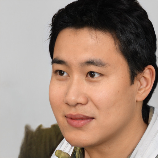 Joyful asian young-adult male with short  black hair and brown eyes