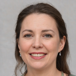 Joyful white adult female with medium  brown hair and grey eyes