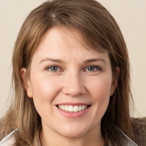 Joyful white young-adult female with long  brown hair and grey eyes