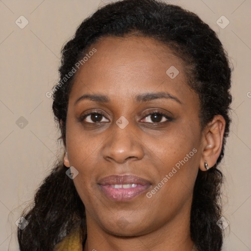 Joyful black young-adult female with long  brown hair and brown eyes
