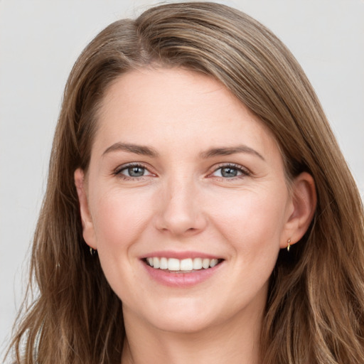 Joyful white young-adult female with long  brown hair and grey eyes