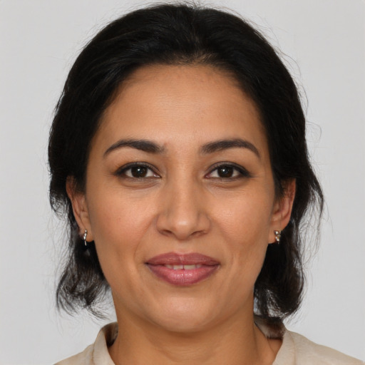 Joyful latino adult female with medium  brown hair and brown eyes