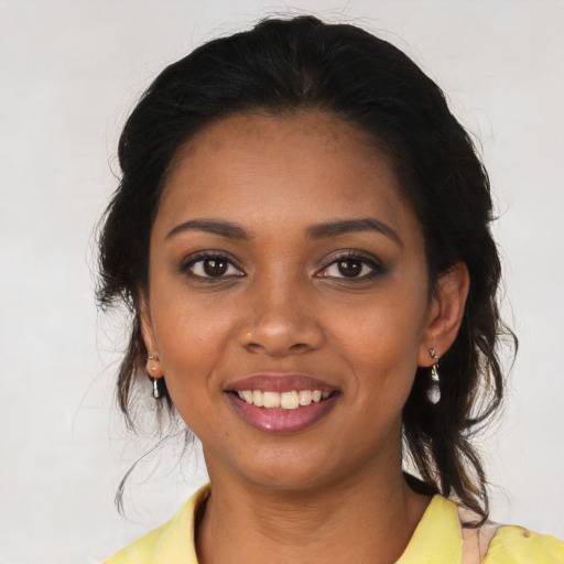 Joyful black young-adult female with long  brown hair and brown eyes