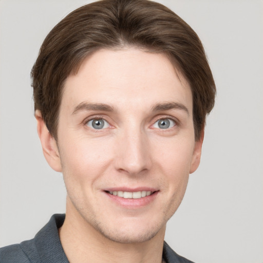 Joyful white young-adult male with short  brown hair and grey eyes