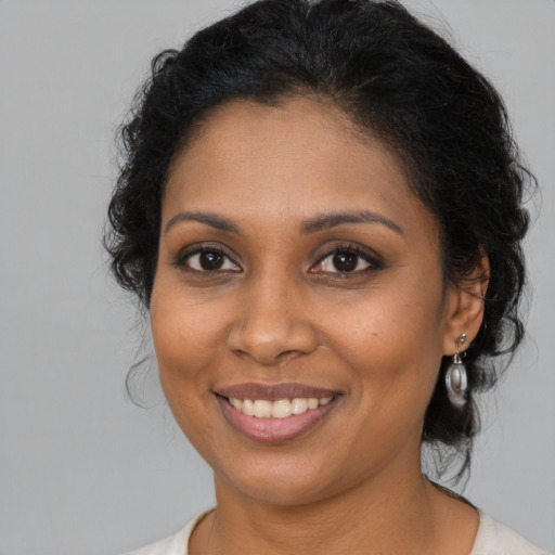 Joyful black young-adult female with medium  brown hair and brown eyes