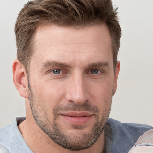 Joyful white adult male with short  brown hair and grey eyes