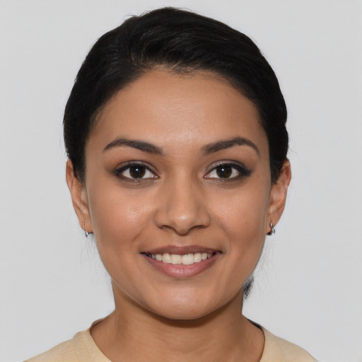 Joyful latino young-adult female with short  black hair and brown eyes