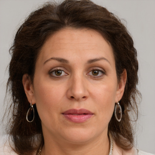 Joyful white adult female with medium  brown hair and green eyes