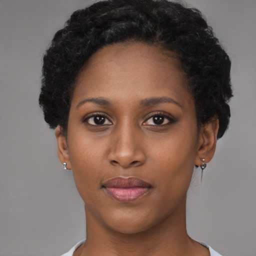 Joyful black young-adult female with short  black hair and brown eyes