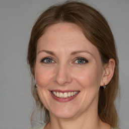 Joyful white adult female with medium  brown hair and grey eyes