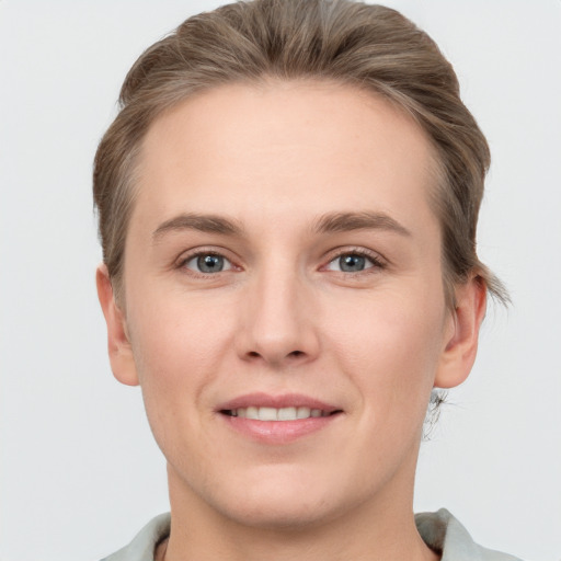 Joyful white young-adult female with short  brown hair and grey eyes