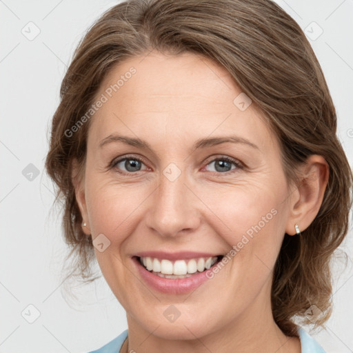 Joyful white adult female with medium  brown hair and grey eyes