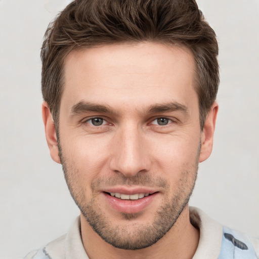 Joyful white young-adult male with short  brown hair and grey eyes