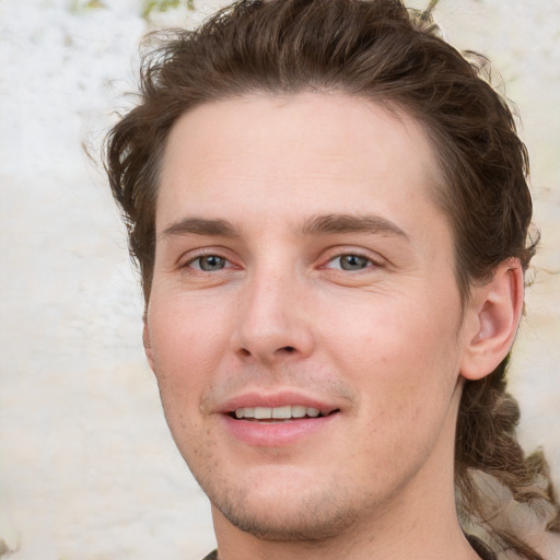 Joyful white young-adult male with medium  brown hair and grey eyes