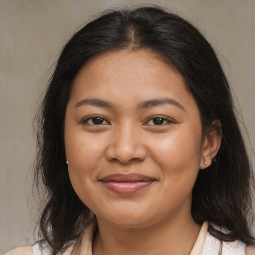 Joyful latino young-adult female with medium  brown hair and brown eyes