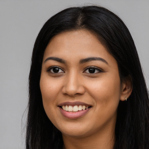 Joyful latino young-adult female with long  black hair and brown eyes