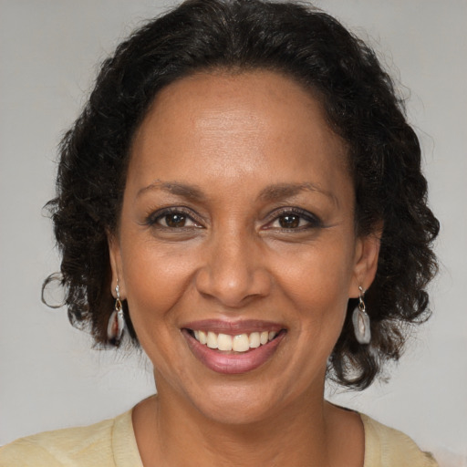 Joyful black adult female with medium  brown hair and brown eyes