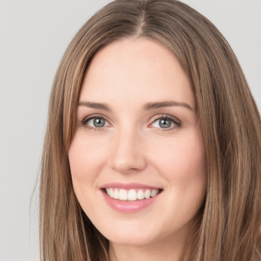 Joyful white young-adult female with long  brown hair and green eyes