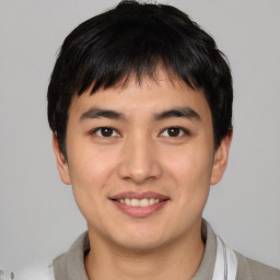 Joyful asian young-adult male with short  brown hair and brown eyes