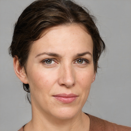 Joyful white adult female with medium  brown hair and grey eyes