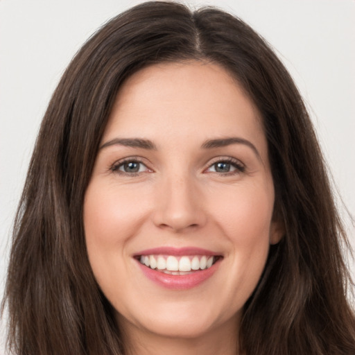 Joyful white young-adult female with long  brown hair and brown eyes